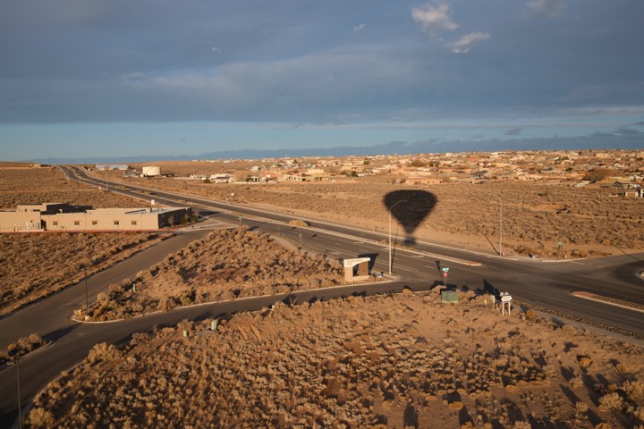A balloon's shadow cast across a desert highway