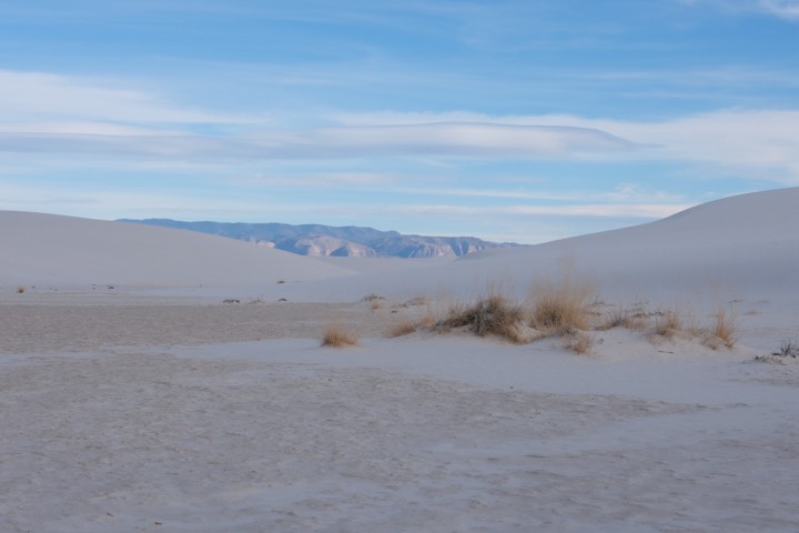 White sand dunes meeting distant mountains