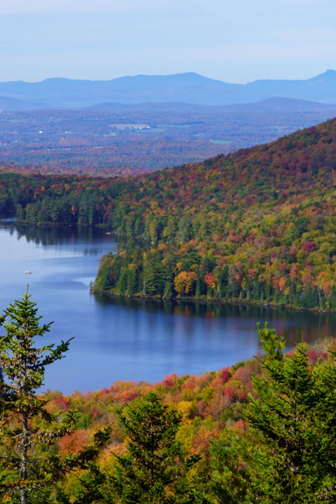 Lake ringed by fall color with distant ridges