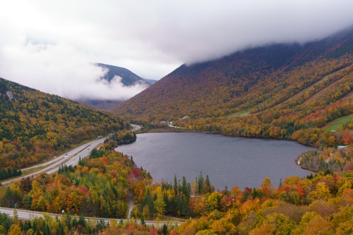 Notch lake below cloud-draped mountains in fall