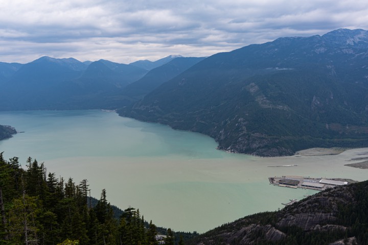Turquoise inlet below forested coastal mountains