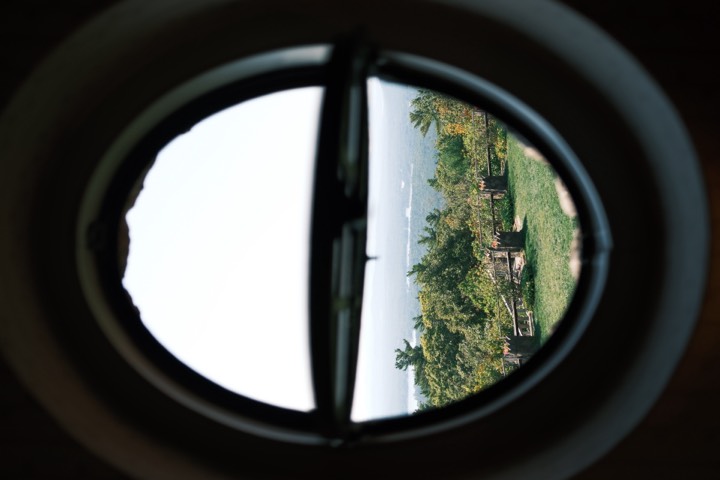 Hillside greenery framed through a round window