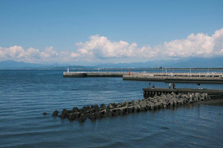 Harbor breakwater under summer clouds