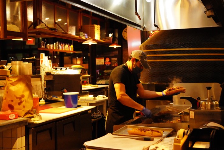 Cook tending the grill in a warmly lit kitchen
