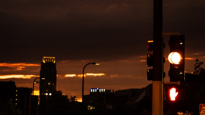 City skyline at dusk behind a glowing traffic light